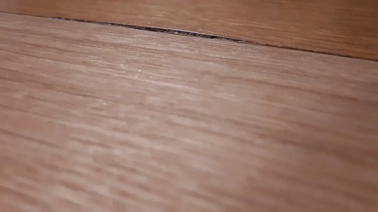 Widoczny spuchnięty blat na łączeniu, który wymaga naprawy.