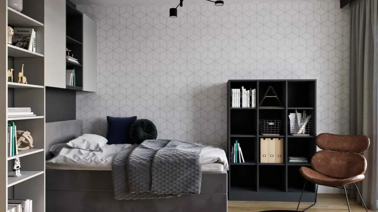 Nowoczesny pokój młodzieżowy dla dziewczyny: inspiracje. Szara tapeta w geometryczne wzory, wygodne łóżko, regały i stylowy fotel.