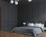 Nowoczesny pokój młodzieżowy z czarną ścianą, łóżkiem i drewnianą podłogą.
