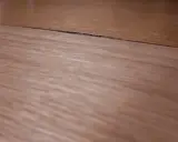 Widoczny spuchnięty blat na łączeniu, który wymaga naprawy.