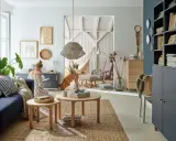 Przytulny salon z kanapą w kolorze blue, fotelem, hamakiem i psem.