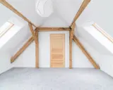 Jasne, nowoczesne belki na poddaszu aranżacje. Dachowe okna, drewniane belki i jasna, przestronna przestrzeń.