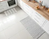 Dwa dywaniki na jasnej podłodze w kuchni: jeden w paski, drugi z geometrycznym wzorem.