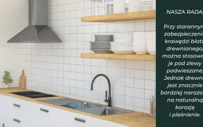 Nowoczesna kuchnia z drewnianym blatem, pod którym zamontowano zlew podwieszany. Białe płytki i stalowy okap tworzą czysty design.