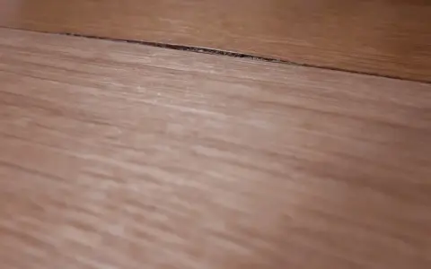 Widoczny spuchnięty blat na łączeniu, który wymaga naprawy.