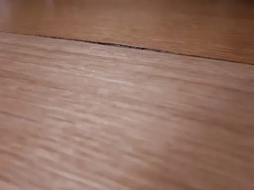 Widoczny spuchnięty blat na łączeniu, który wymaga naprawy.