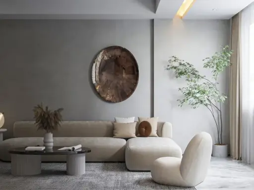 Minimalizm w domu: beżowa sofa, okrągłe lustro i drzewko w donicy tworzą spokojną przestrzeń.