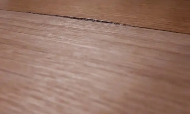 Widoczny spuchnięty blat na łączeniu, który wymaga naprawy.